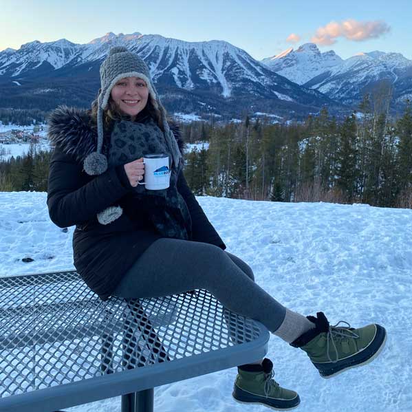 Woman drinking tea with Canadian Rockies behind