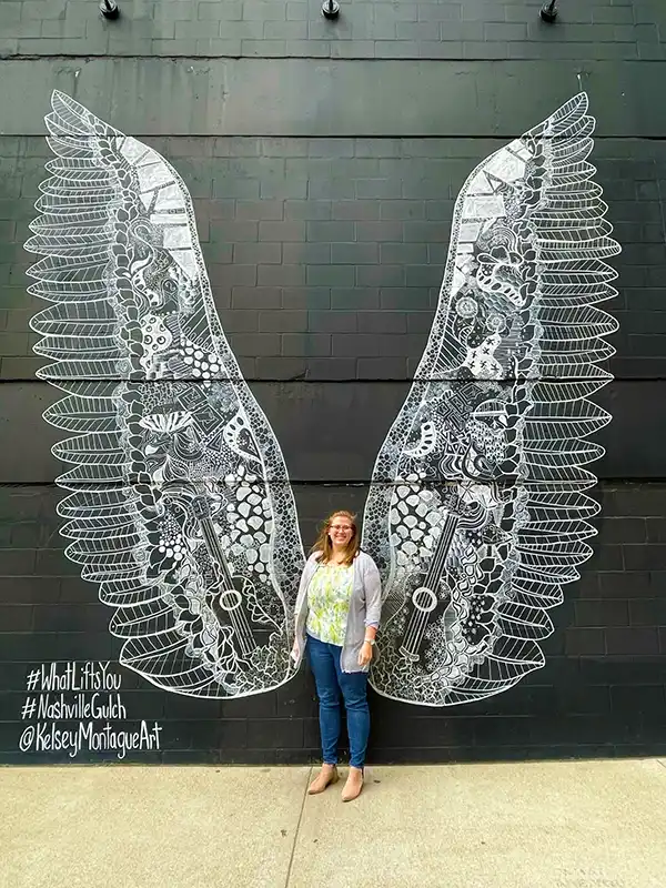 nashville-wings A person stands in front of the "What Lifts You" angel wings mural by Kelsey Montague in Nashville's Gulch neighborhood.